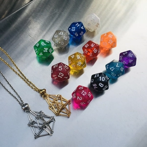 Macro shot of colorful D20 dice set and geometric metal cage pendant necklaces