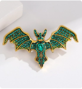 Detail of bat brooch with emerald green crystals and rhinestones on gold base