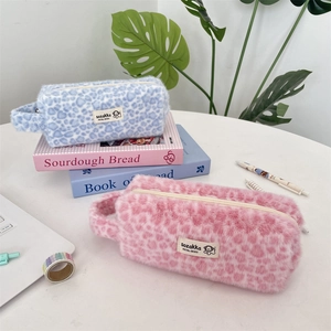 Detail of blue and pink plush leopard print cosmetic bags with soft faux fur texture