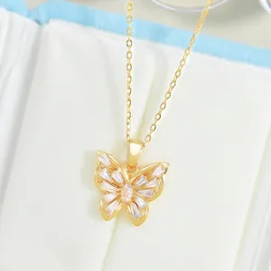 Close-up of golden butterfly pendant with sparkling cubic zirconia in jewelry box