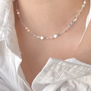 Detail shot of 925 sterling silver choker necklace with tiny disc pendants on a neck