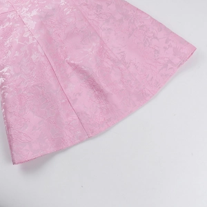 Gros plan sur un tissu jacquard rose avec motifs floraux élégants et texture tissée