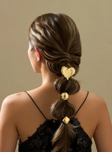 Detailed view of geometric golden metal hair buckles in heart, circle, and diamond shapes