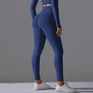 Detail view of seamless high-waisted yoga leggings and long sleeve top in dark blue