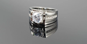Macro detail of men's titanium ring with center round gem and side diamond accents