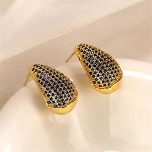 Macro detail of gold teardrop earrings featuring micro-set blue cubic zirconia stones