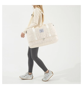 Model showing large cream nylon fitness bag with star quilting and separate shoe compartment