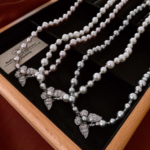 Détail de colliers de perles multicolores avec fermoirs papillon en zircon dans un plateau