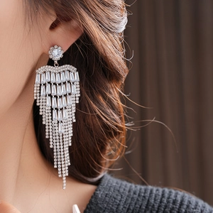 Macro detail of silver tassel earrings with multilayered white cubic zirconia settings