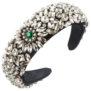 Detail of luxury padded headband with emerald green stone and sparkling rhinestones