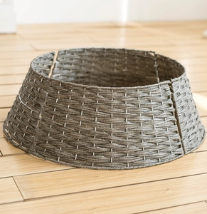 Support de pied de sapin de Noël minimaliste en rotin tressé gris sur parquet clair