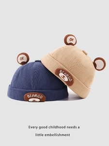 Detail of corduroy infant caps with cute bear embroidery and 3D ears in navy and beige