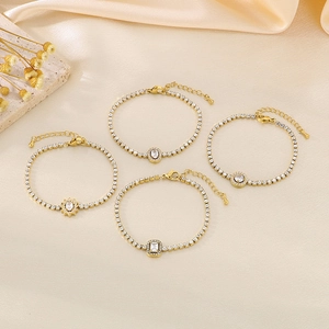 Detailed macro view of four vintage gold bracelets featuring emerald green zircon pendants
