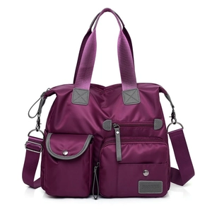 Close-up of waterproof purple oxford fabric and multi-pocket detail on casual handbag
