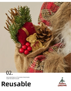 Detail of Christmas burlap gift bag with teddy bear, pine cones, and red berries