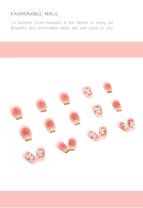 Detailed view of pink gradient press-on nails with white 3D flower and gold foil accents