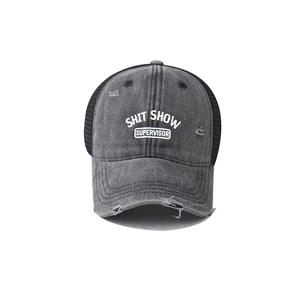 Close-up of distressed denim trucker hat with Shit Show Supervisor text and mesh detail