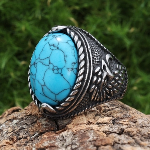 Detailed close-up of eagle feather carvings on a vintage turquoise stainless steel ring