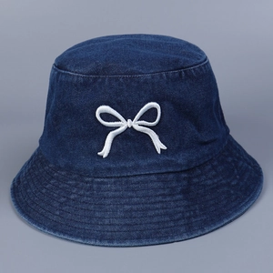Detailansicht der weißen Schleifenstickerei auf einem marineblauen Denim Fischerhut aus Stoff
