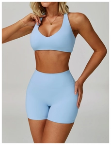 Close-up of seamless light blue yoga set featuring a deep V sports bra and high-waist shorts