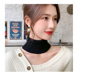 Close-up of black knit false collar turtleneck accessory styled with a white cardigan