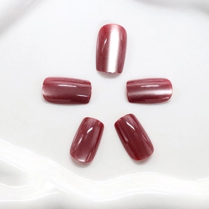 Short square dark red cat eye press-on nails with magnetic shimmer on a white tray