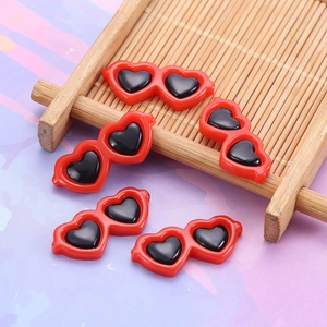 Macro view of five miniature red heart-shaped sunglasses resin DIY craft accessories