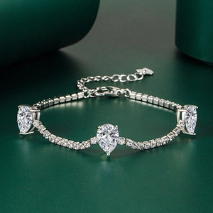 Detail of silver bracelet with pear-cut cubic zirconia stones and heart charm extension