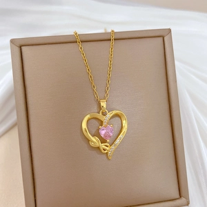 Macro detail of heart pendant necklace with pink gemstone and clear crystal inlay