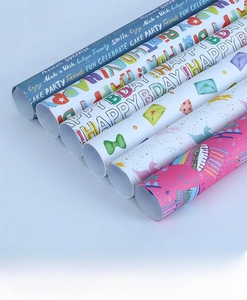 Détail de rouleaux de papier cadeau variés avec motifs d'anniversaire et arc-en-ciel