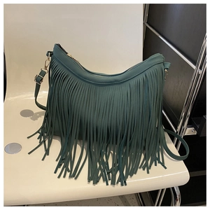 Detailed close-up of dark green PU leather crossbody bag with long vertical fringe