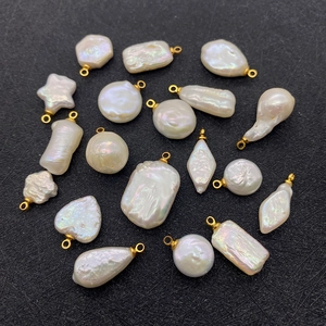 Detailed view of assorted baroque pearl pendants with gold loops for DIY jewelry making