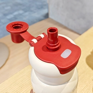 Detail view of the red sports water bottle lid with upright straw nozzle and flip-top cover
