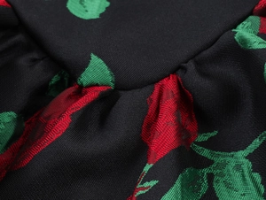 Vue détaillée du tissu tissé avec des motifs floraux de roses rouges sur fond noir