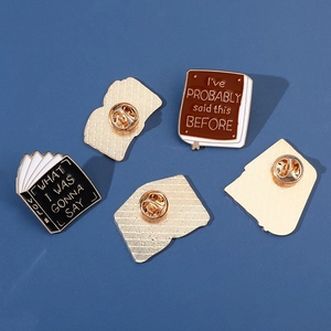 Set of four enamel book pins with quotes on a blue background showing front and back