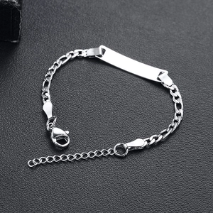 Detailed macro view of silver stainless steel ID plate bracelet with adjustable Figaro chain