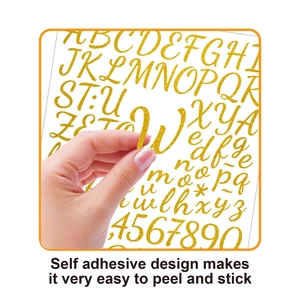Close-up of gold glitter letter stickers being peeled to show self-adhesive backing