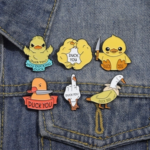 Funny enamel duck pins set with humorous slogans on blue denim jacket pocket