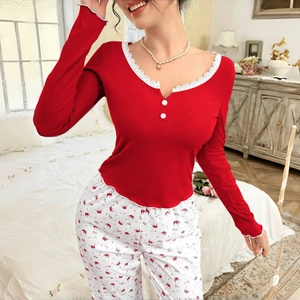 Women's pajama set featuring red long-sleeve ribbed top with white lace and crown print pants