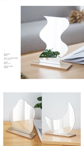 Three irregular acrylic mirrors in wave cloud and moon shapes on wooden bases