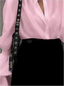 Detail view of pink chiffon shirt fabric with white buttons and elegant lantern sleeves