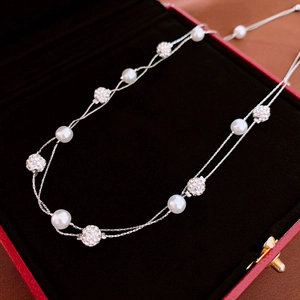 Close-up of double-layer faux pearl necklace with pavé crystal balls in red jewelry box