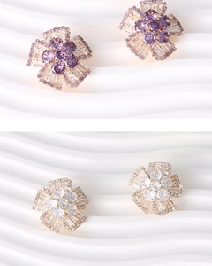 Macro detail of layered flower stud earrings with purple and white zircon crystals