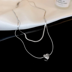 Silver double layer necklace featuring herringbone chain and polished heart pendant detail