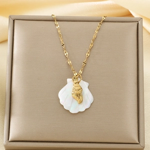 Detail of 18K gold plated necklace with white shell and golden conch pendant in jewelry box