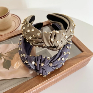 Detail of knotted satin headbands with sparkling rhinestones in olive green and blue