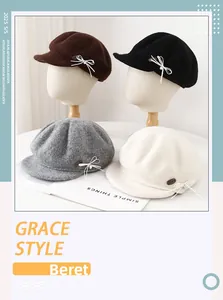 Close-up of wool blend newsboy cap with bow detail and metallic logo in four colors