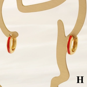 Detail of 18K gold plated hoop earring with red enamel on artistic portrait stand