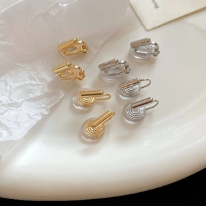 Detailed view of silver and gold geometric clip-on earring converters with silicone pads