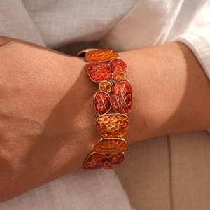 Detail of vintage enamel geometric bracelet with amber tones and gold-plated casing